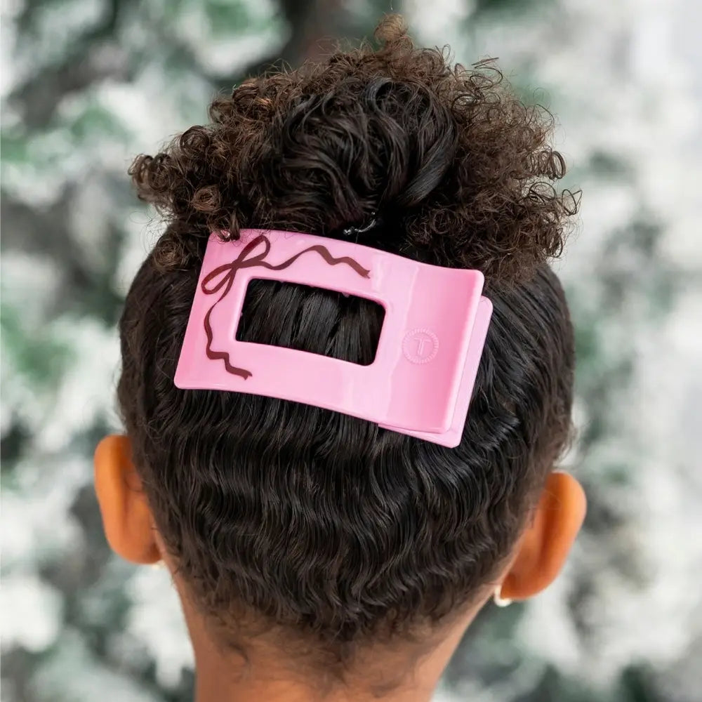 Teleties Just Add A Bow Small Flat Rectangle Hair Clip in pink holding a curly bun