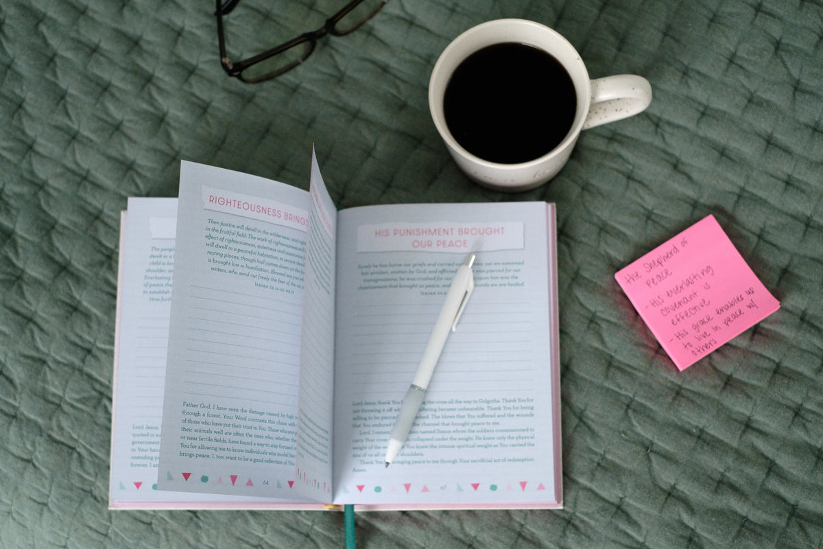 Praying Your Way to a Positive Mindset journal, open beside coffee and pen
