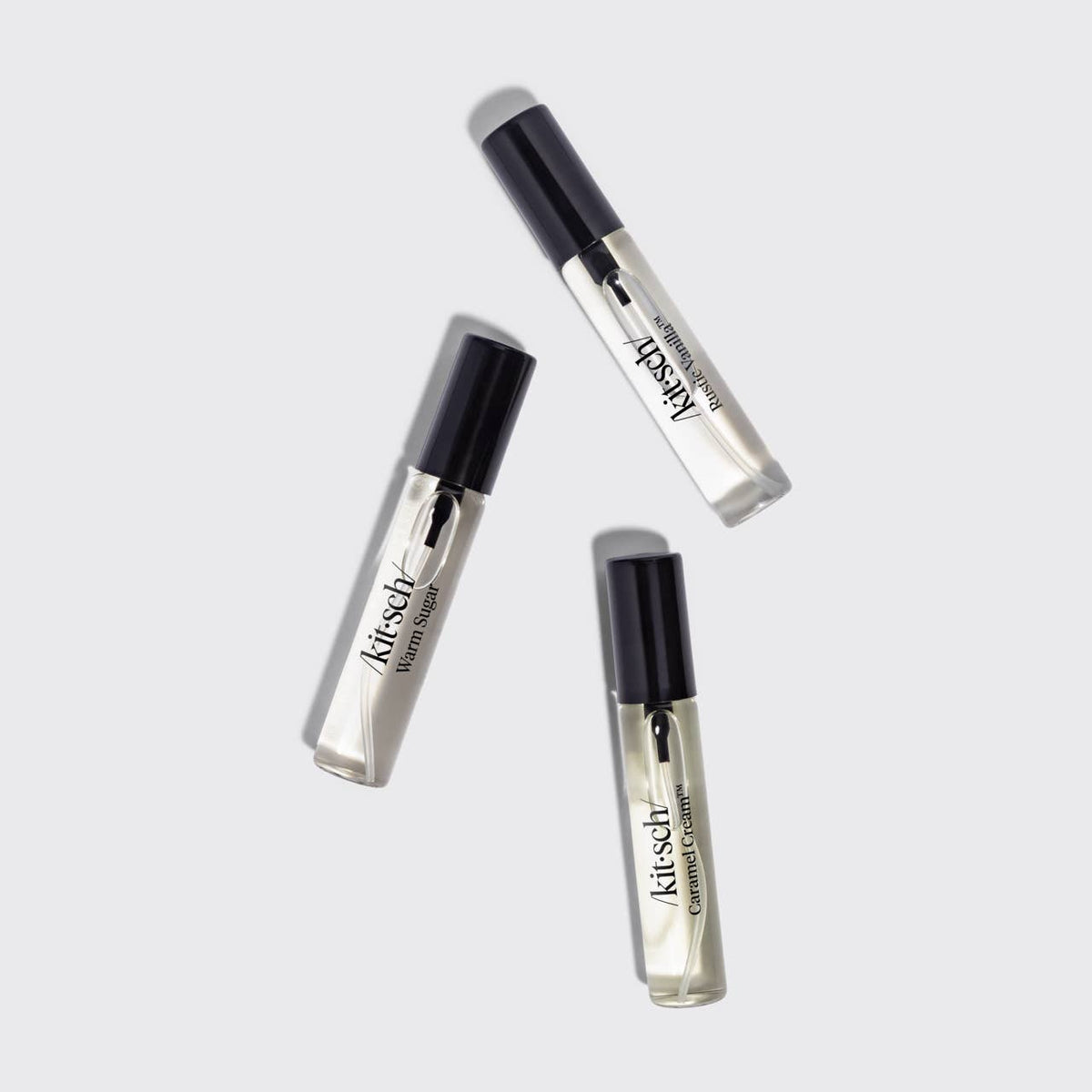 Kitsch Vanilla Vault hair perfume trio, three clear spray vials scattered flat