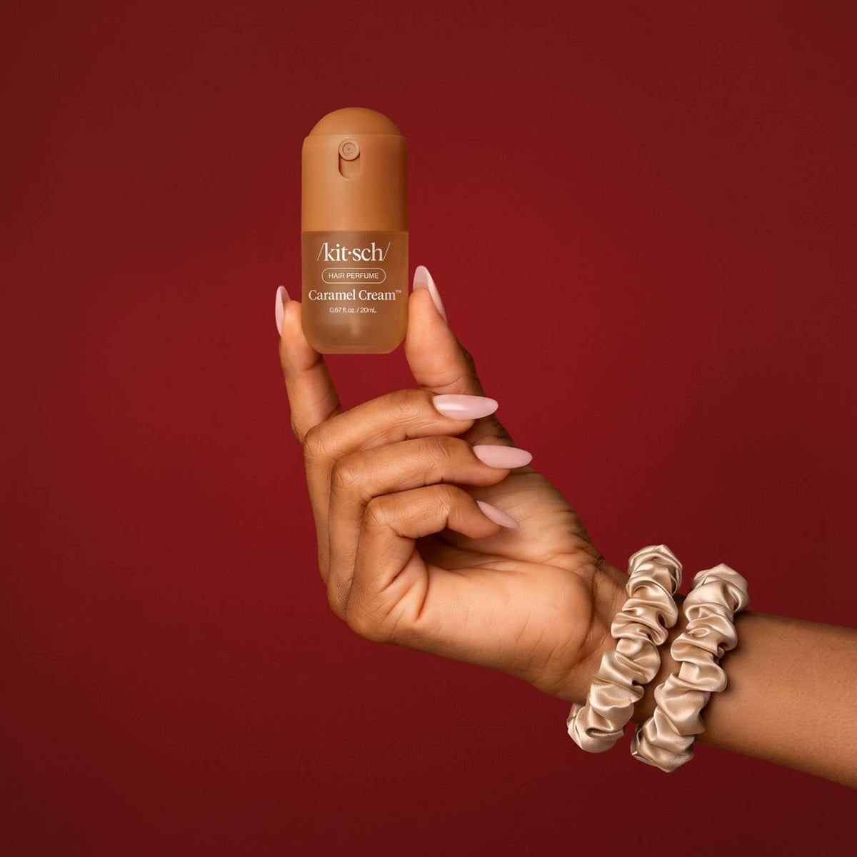 Kitsch Sweet and Silky Caramel Cream mini mist held up with satin scrunchies on the wrist