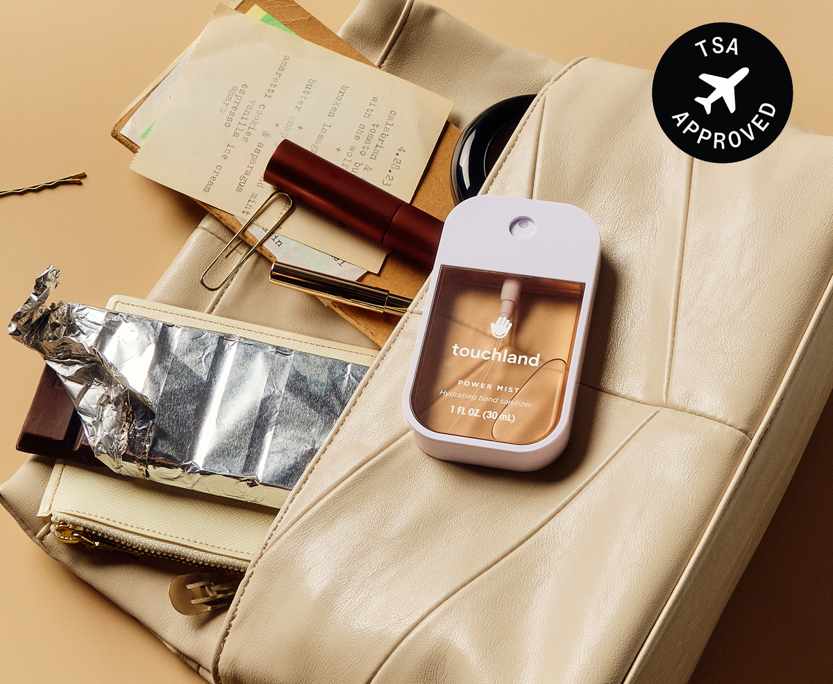 Touchland Midnight S'mores Power Mist on a cream leather bag with TSA approved badge