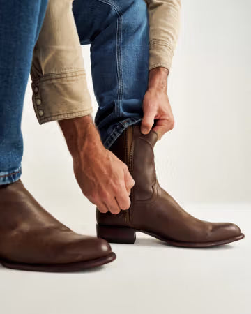 Brown Tecovas western boots with leather sole and traditional pull straps