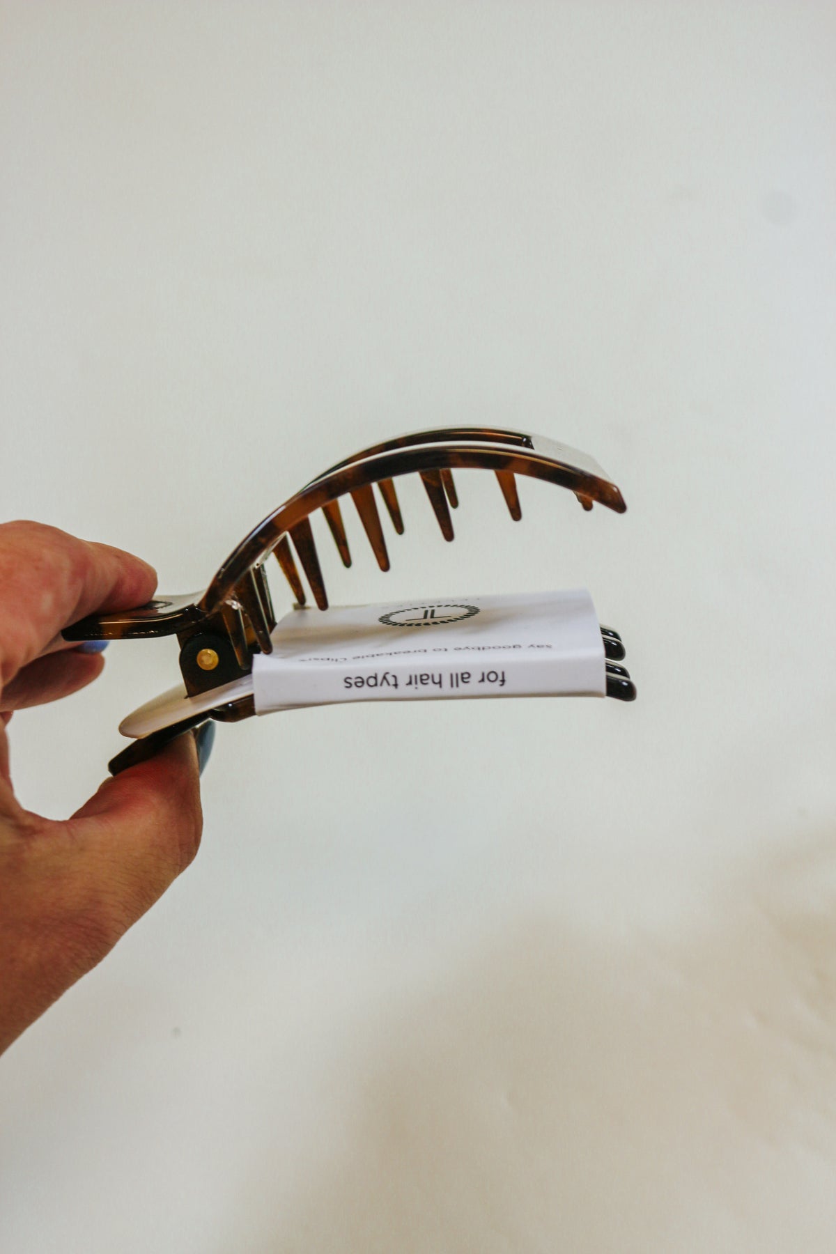 TELETIES Medium Tortoise Square Clip held in hand, side view of the teeth