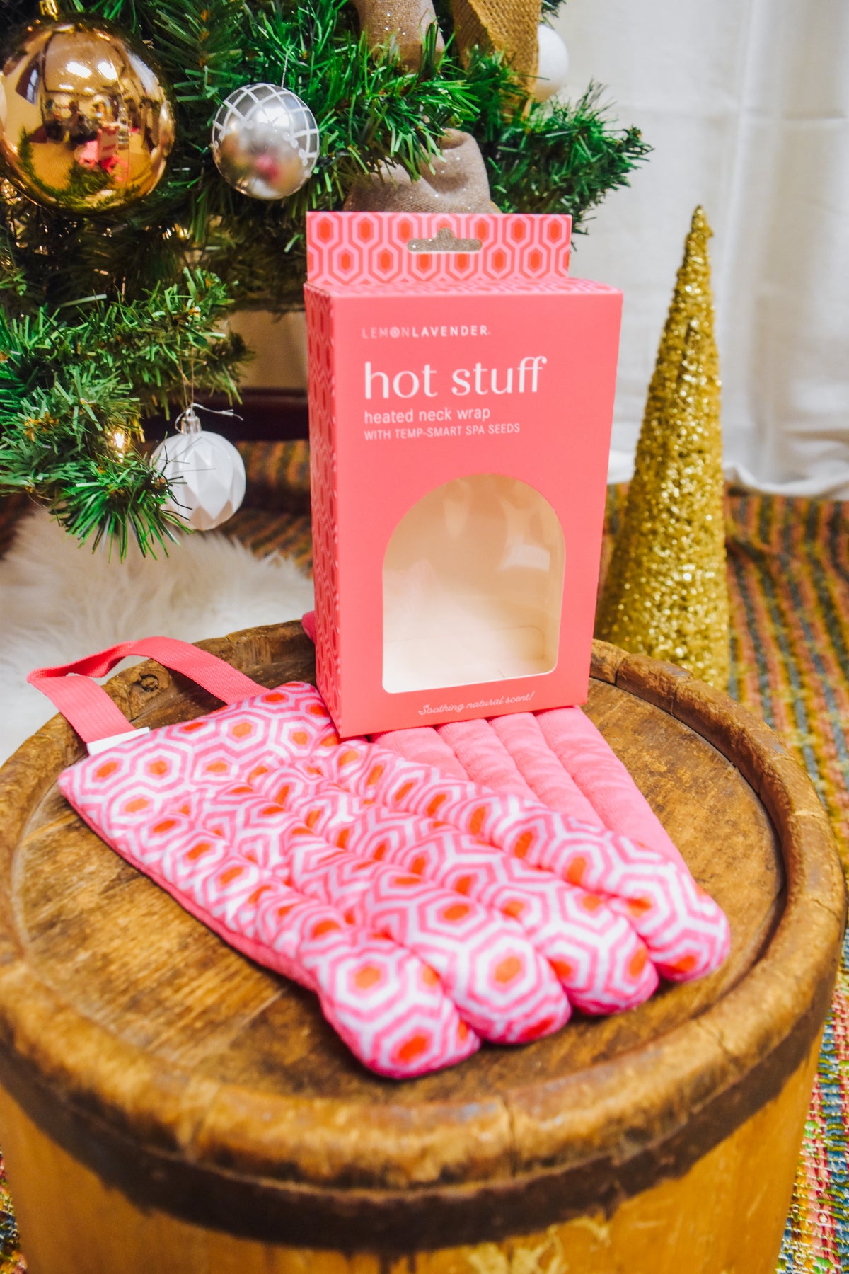Hot Stuff Heated Neck Wrap in hot pink, wrap laid out in front of its open box