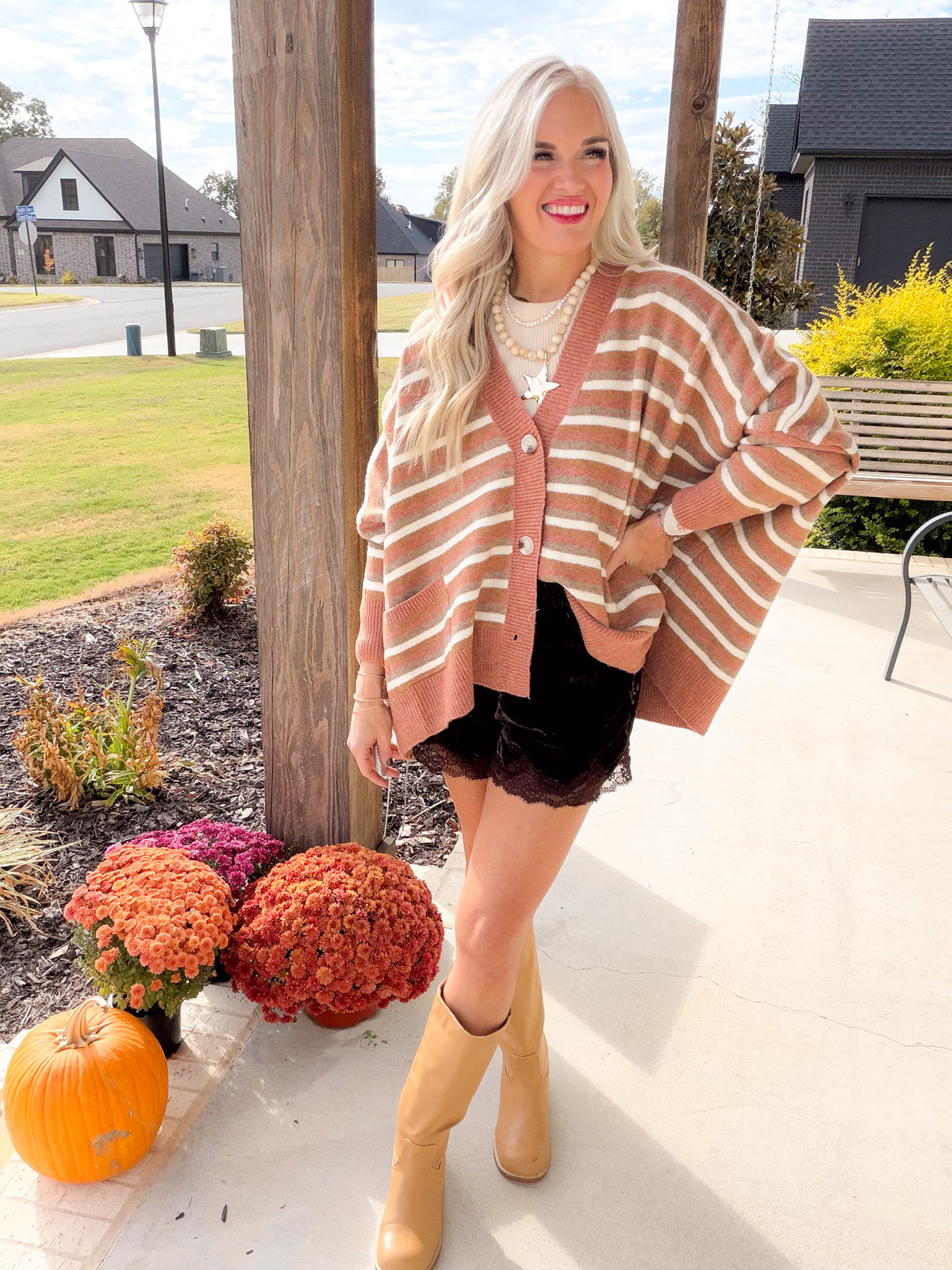 Oversized Camel Multi striped cardigan with a button front, styled with a black lace-trim skirt and tan boots.