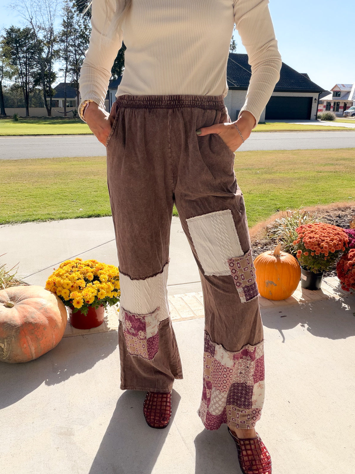 Front detail of women's chocolate paisley patchwork pants with elastic waist, side pockets and cream panels.