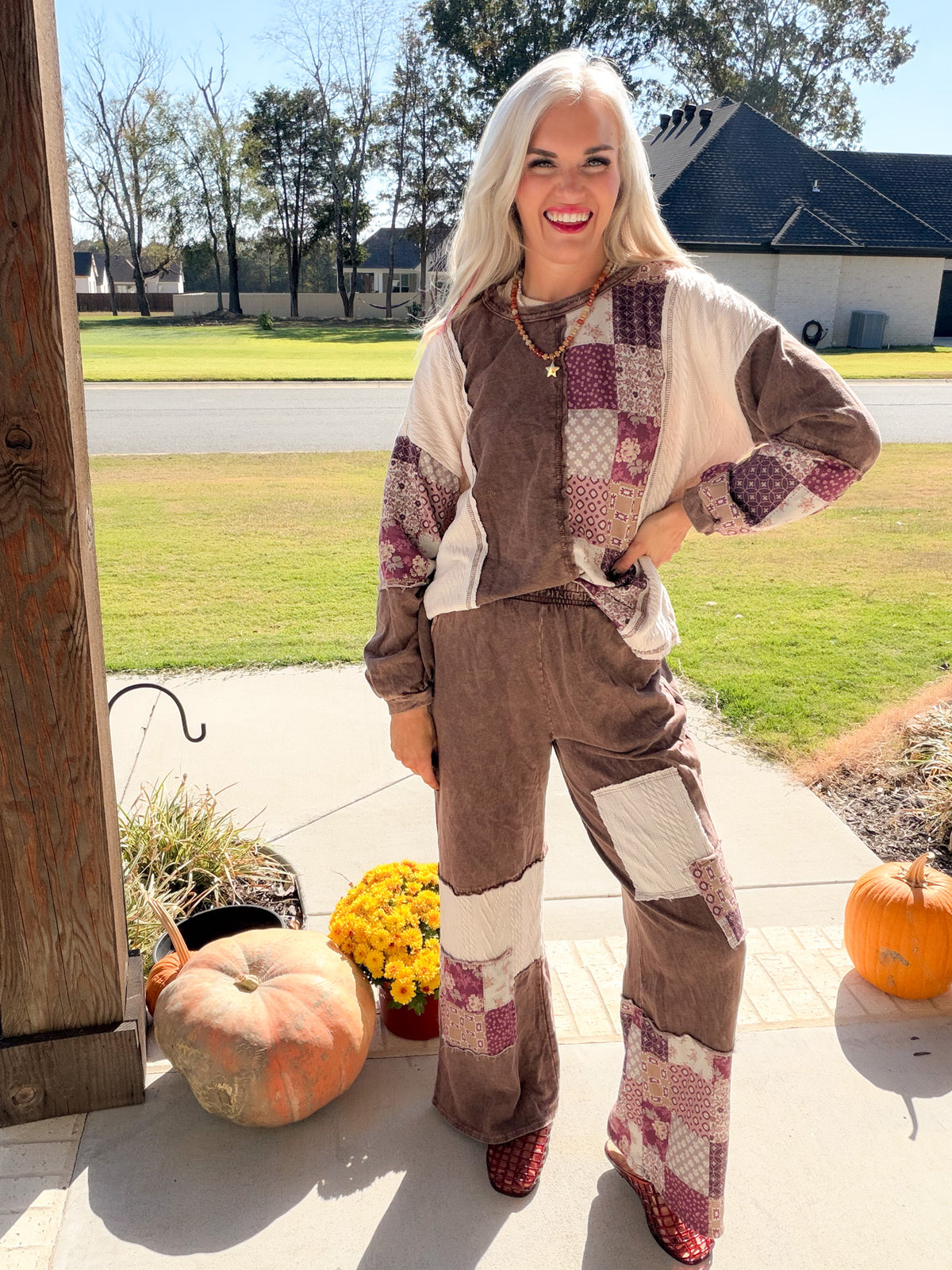 Full-length front view of chocolate paisley patchwork wide-leg pants styled with the matching sweatshirt.