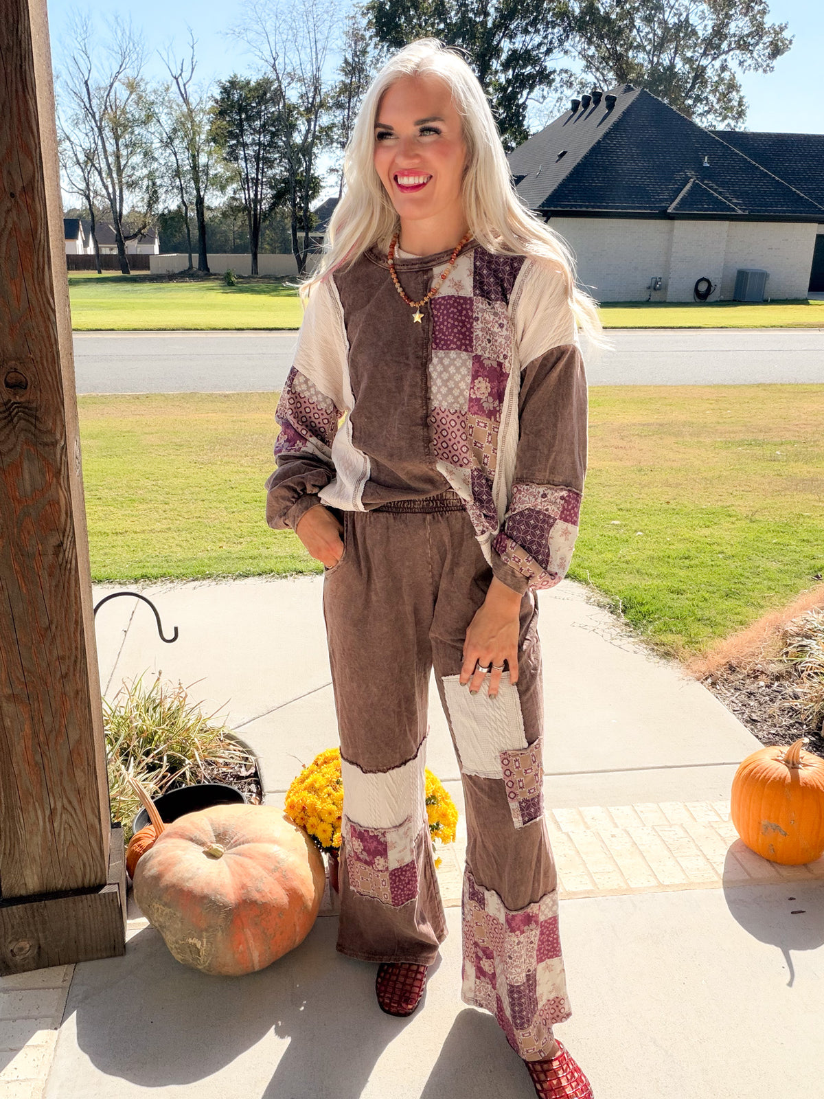 Full-length front view of chocolate paisley patchwork top styled with matching wide-leg pants and red clogs