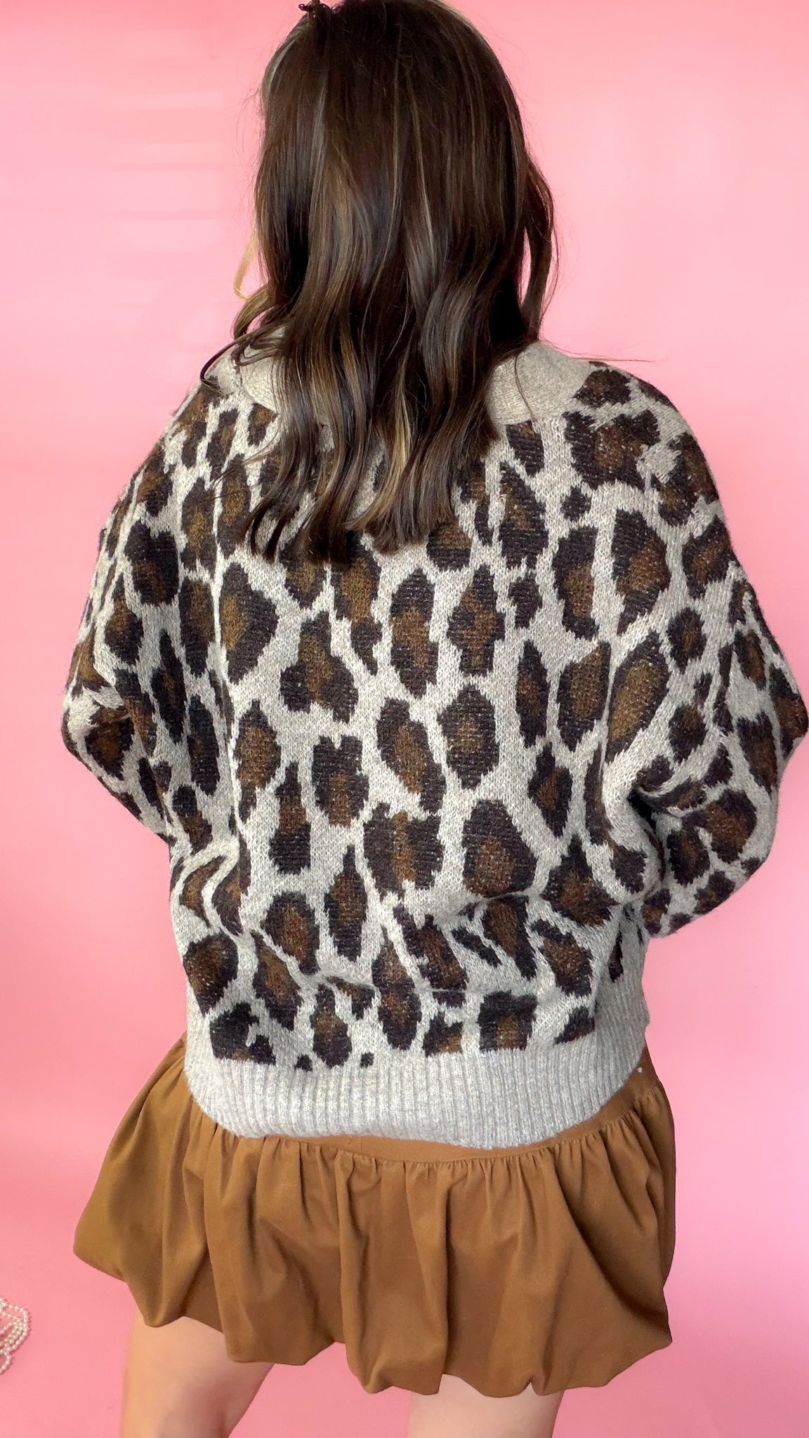 Leopard print sweater cardigan with button-down front and long sleeves worn by a model.