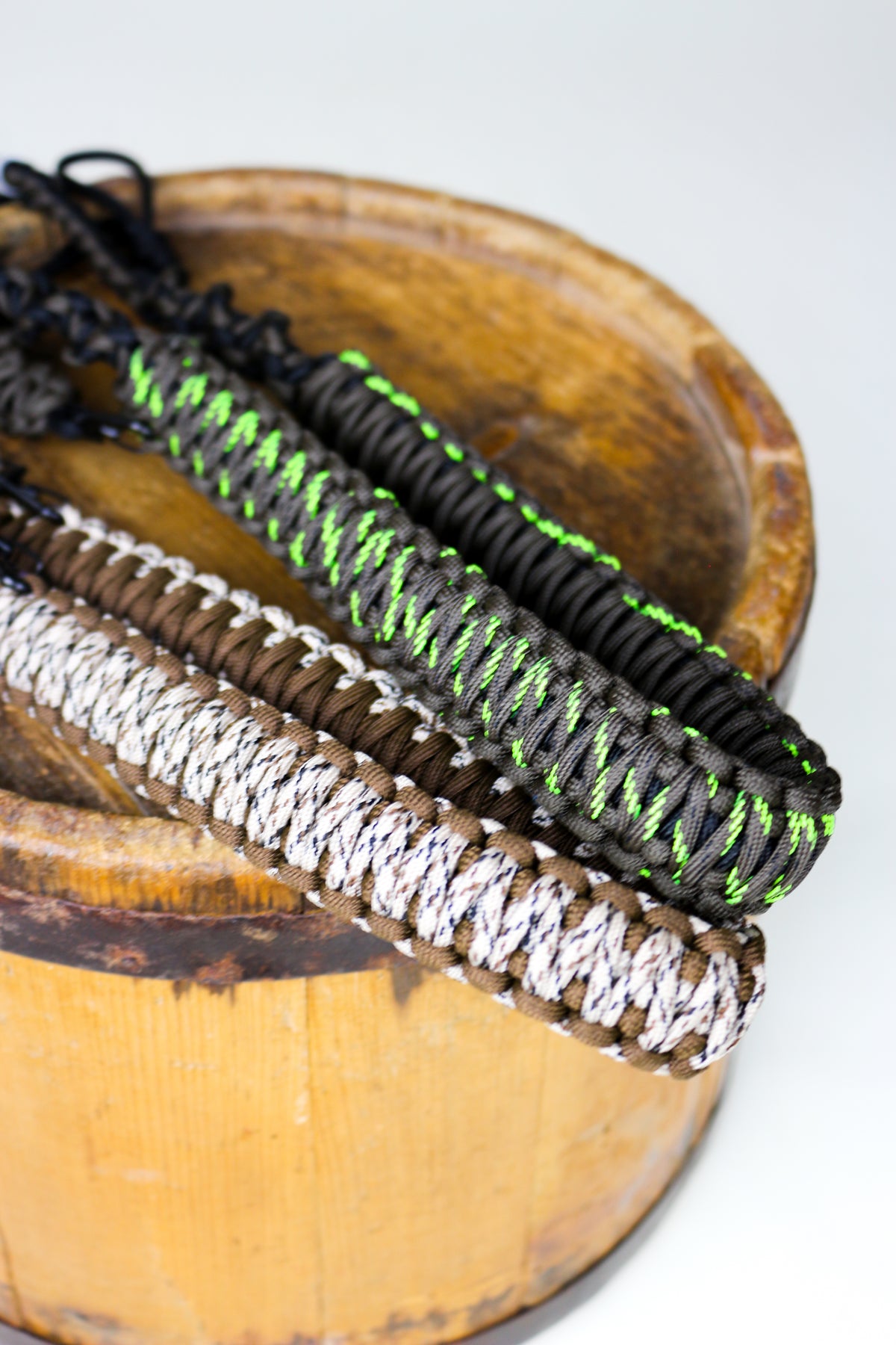 Drake Paracord Duck Caller's Lanyard shown with black olive and camo cord colors on a barrel