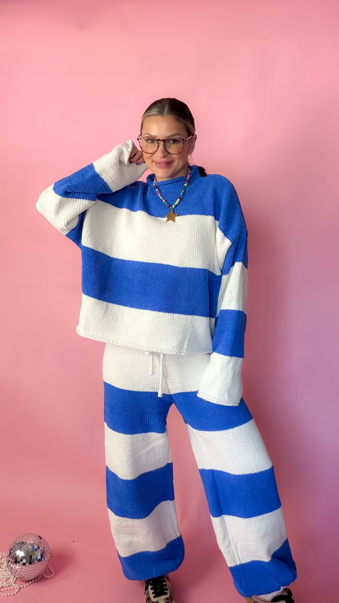 woman wearing blue stripe knit sweater against pink background