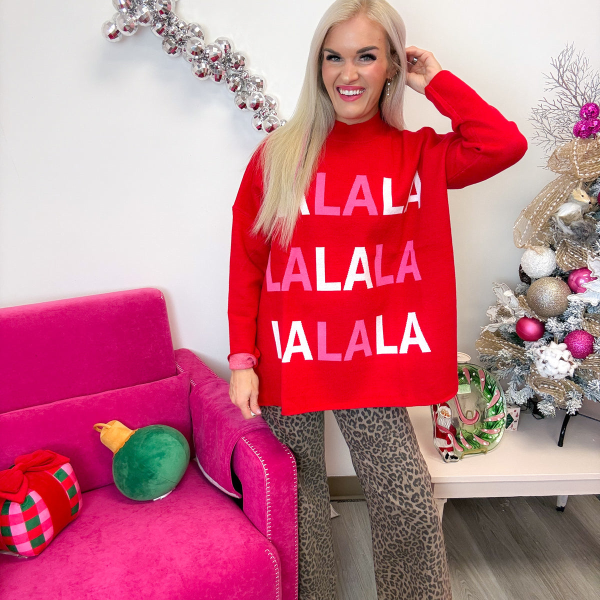 Mud Pie red FA LA LA jacquard Christmas sweater worn with leopard pants, front view