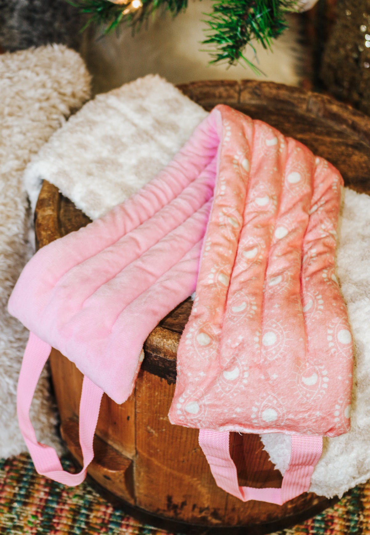 Hot Stuff Heated Neck Wrap in light pink, two wraps showing the plush and printed sides