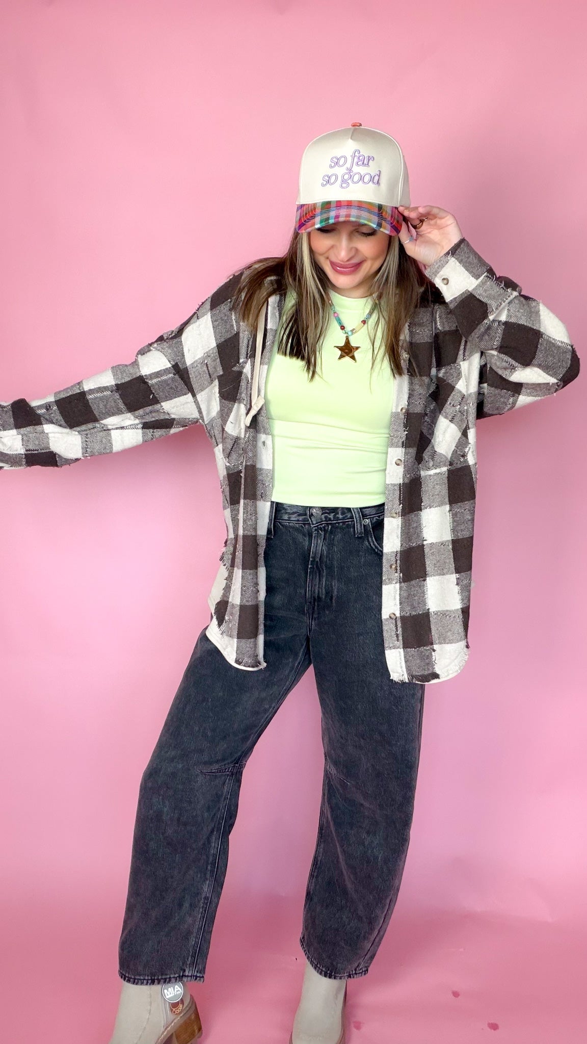 So Far So Good Plaid Trucker Hat worn by model with black and white flannel and jeans