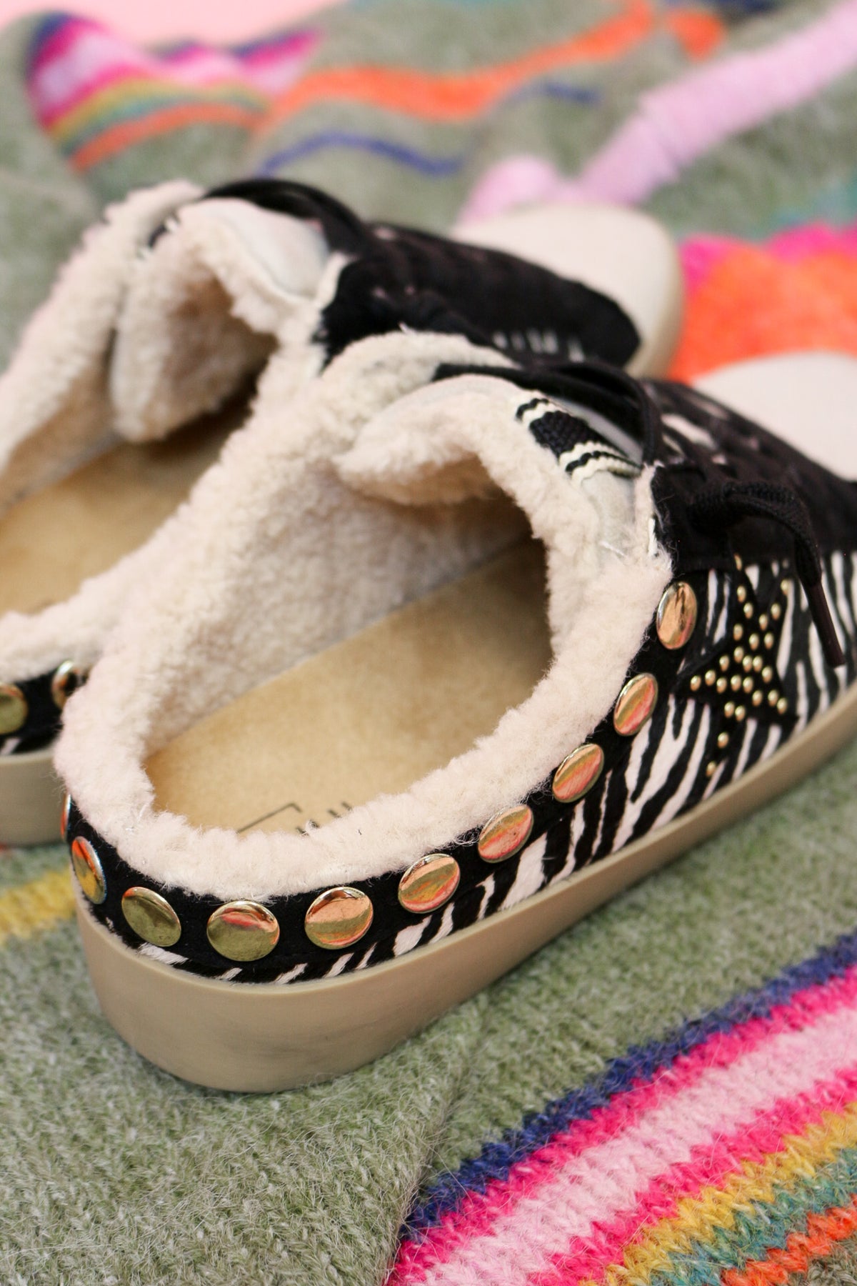 Close-up of the Pippa sneaker heel with gold studs and sherpa lining