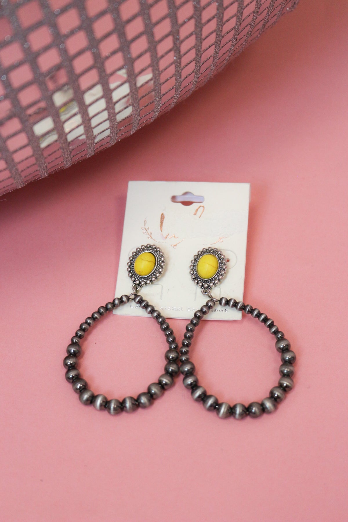Western earrings with bright yellow oval accents in ornate silver-tone frames and dangling dark silver-tone beaded hoops.