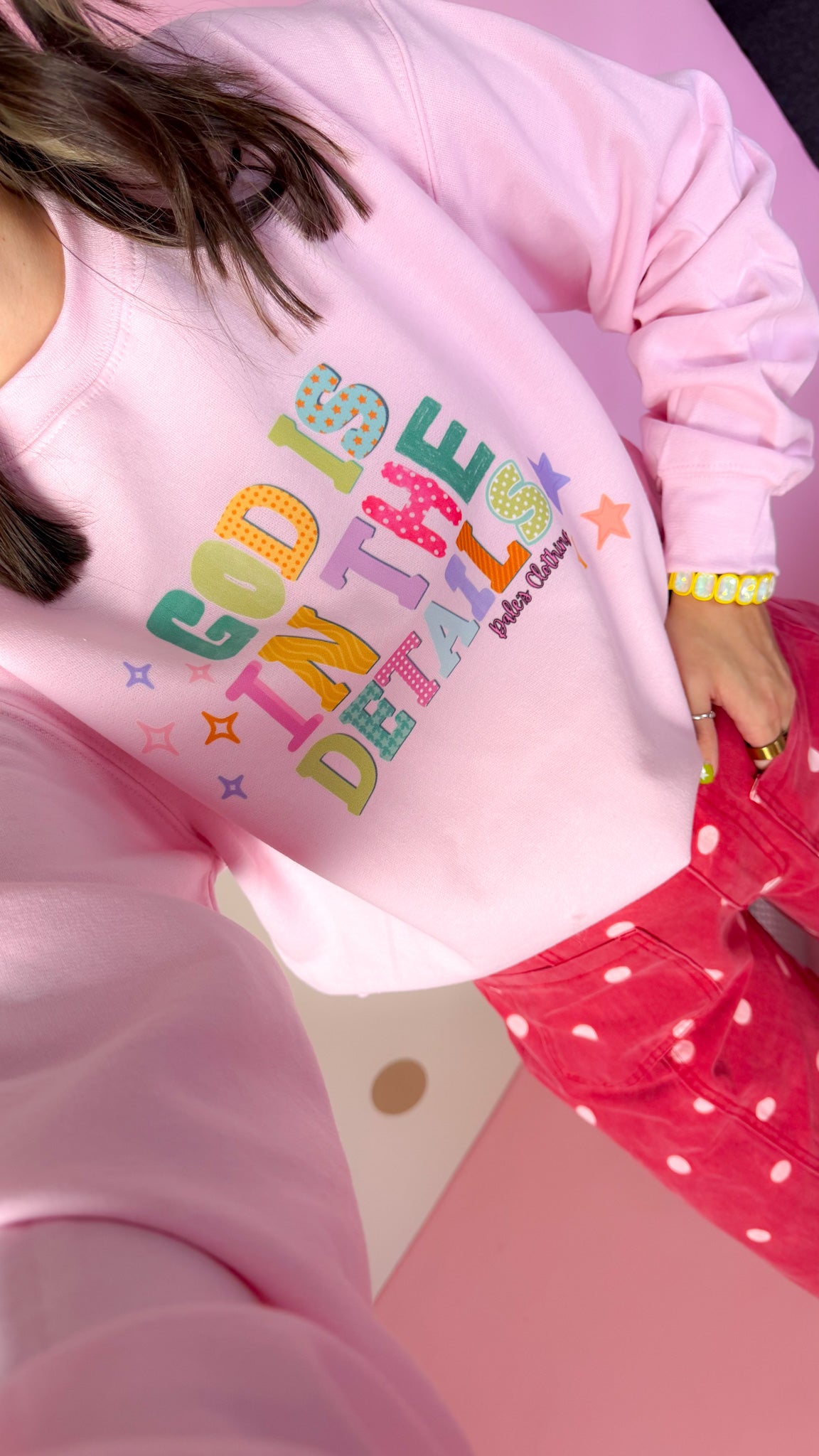 God Is In The Details pink sweatshirt, close-up of colorful lettering