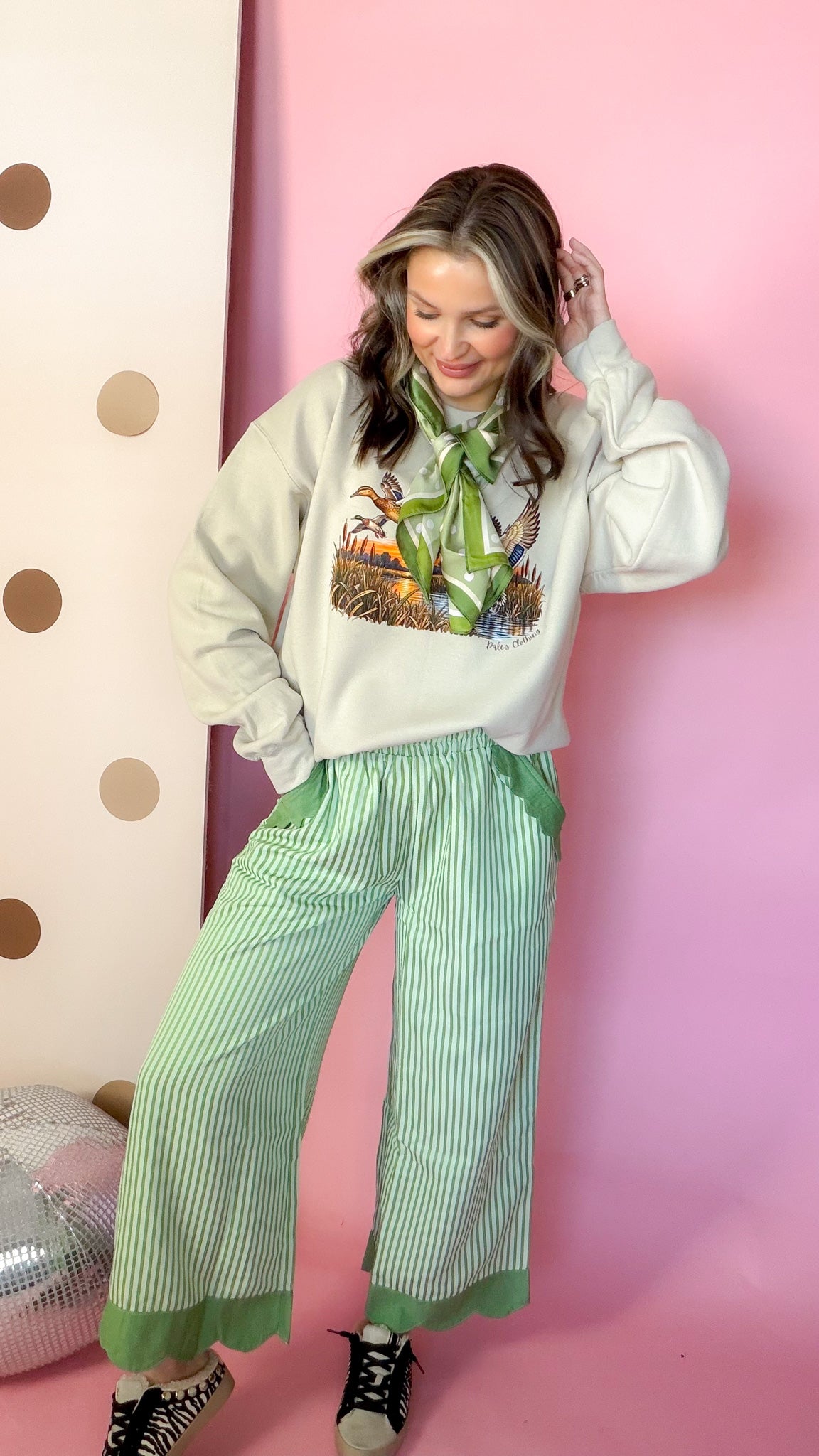 Entire Duck Crew sand sweatshirt styled with green stripe pants
