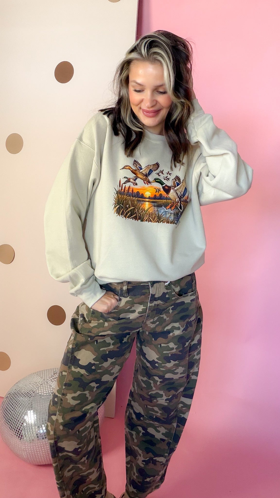 Entire Duck Crew sand sweatshirt, model looking down with hands in pockets