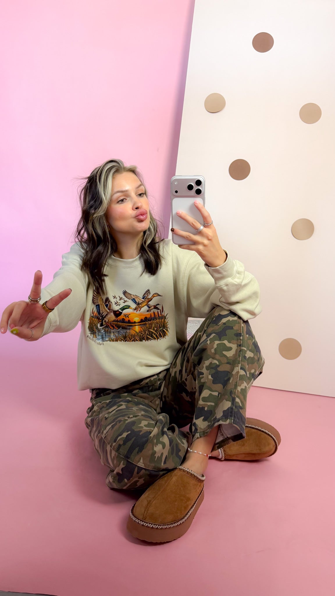 Adelle Linen Entire Duck Crew sand sweatshirt, model seated with camo pants
