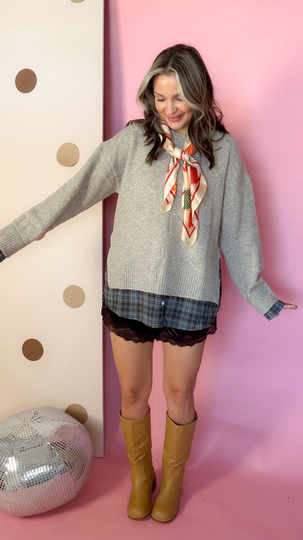 A Warming Welcome sweater, model with arms out and boots