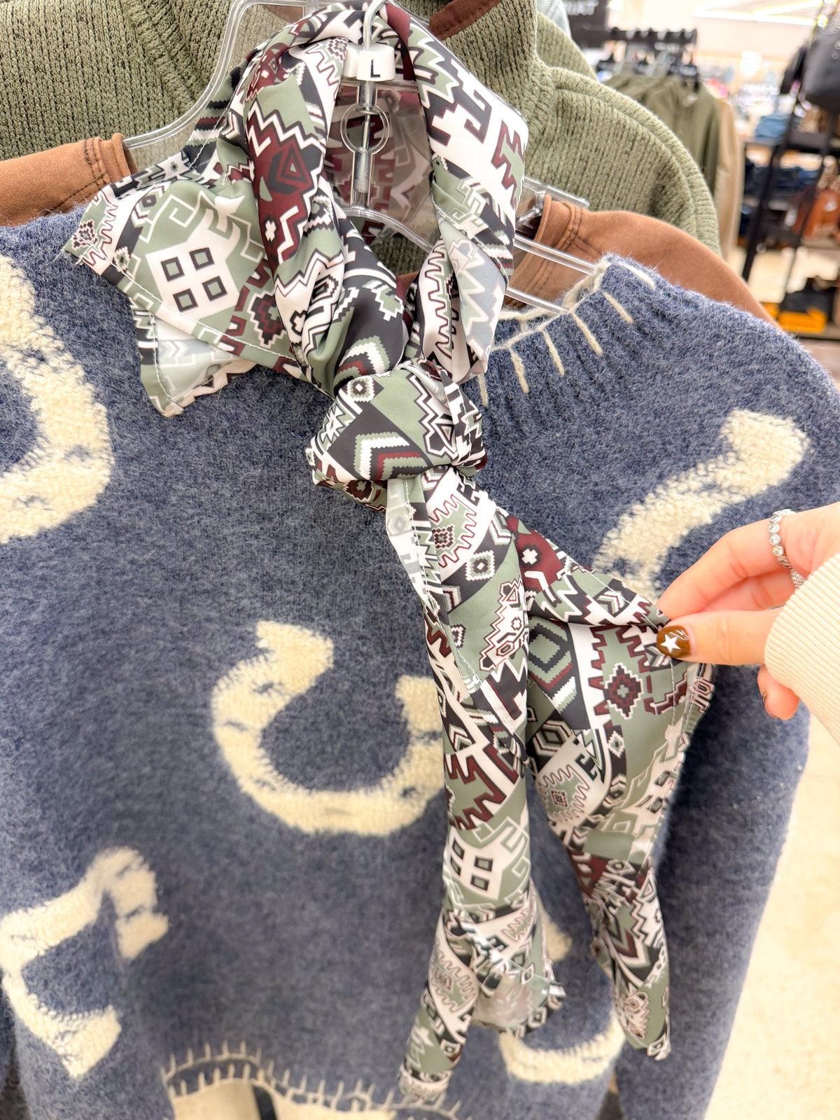 Cinch green Aztec wildrag scarf, close-up of print draped over a sweater