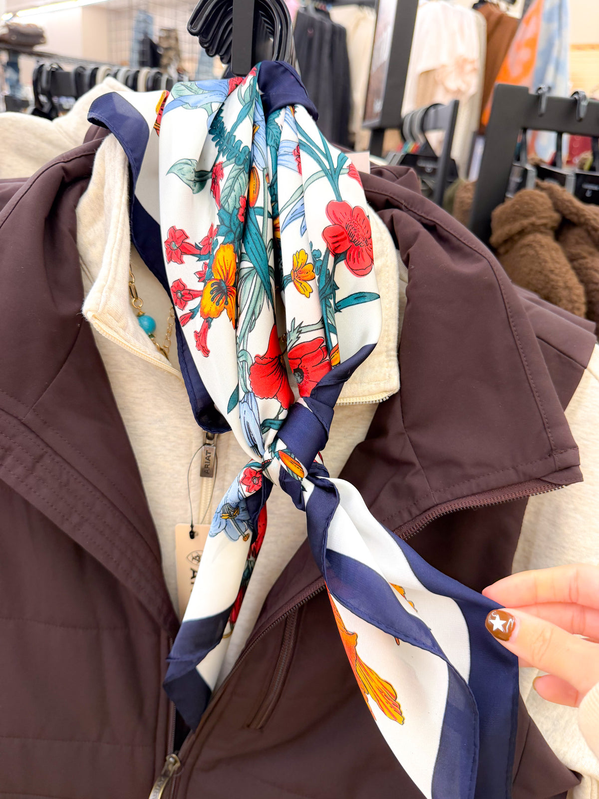 Large floral print bandana scarf knotted on a mannequin over brown vest