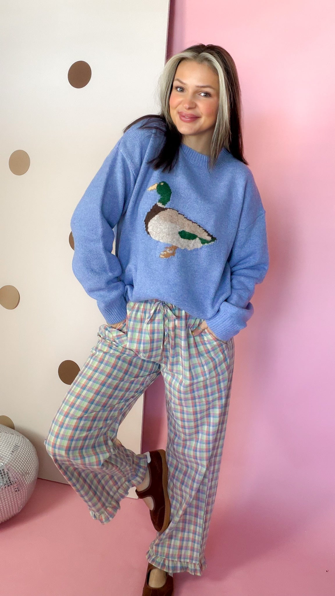 Front view of women's coastal blue mallard sweater with ribbed cuffs, styled with pastel plaid pants.
