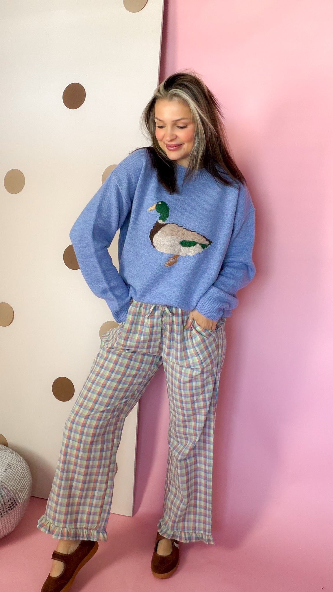 Coral and blue plaid wide-leg ruffle pants styled with a blue duck sweater and brown Mary Jane shoes
