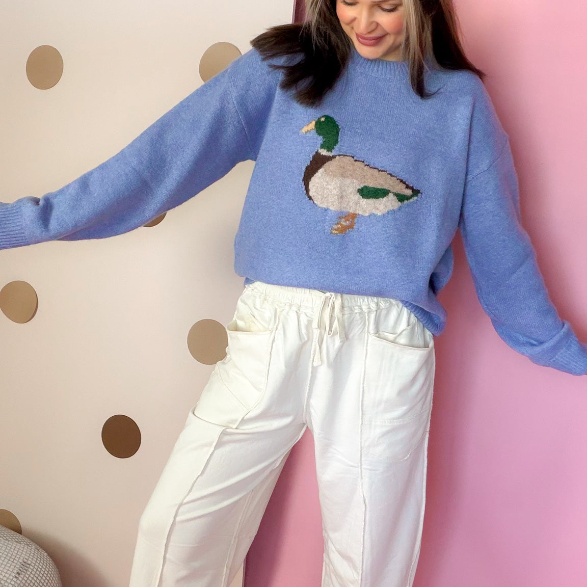 Front view of Ecru barrel pants styled with a blue duck sweater and printed sneakers.