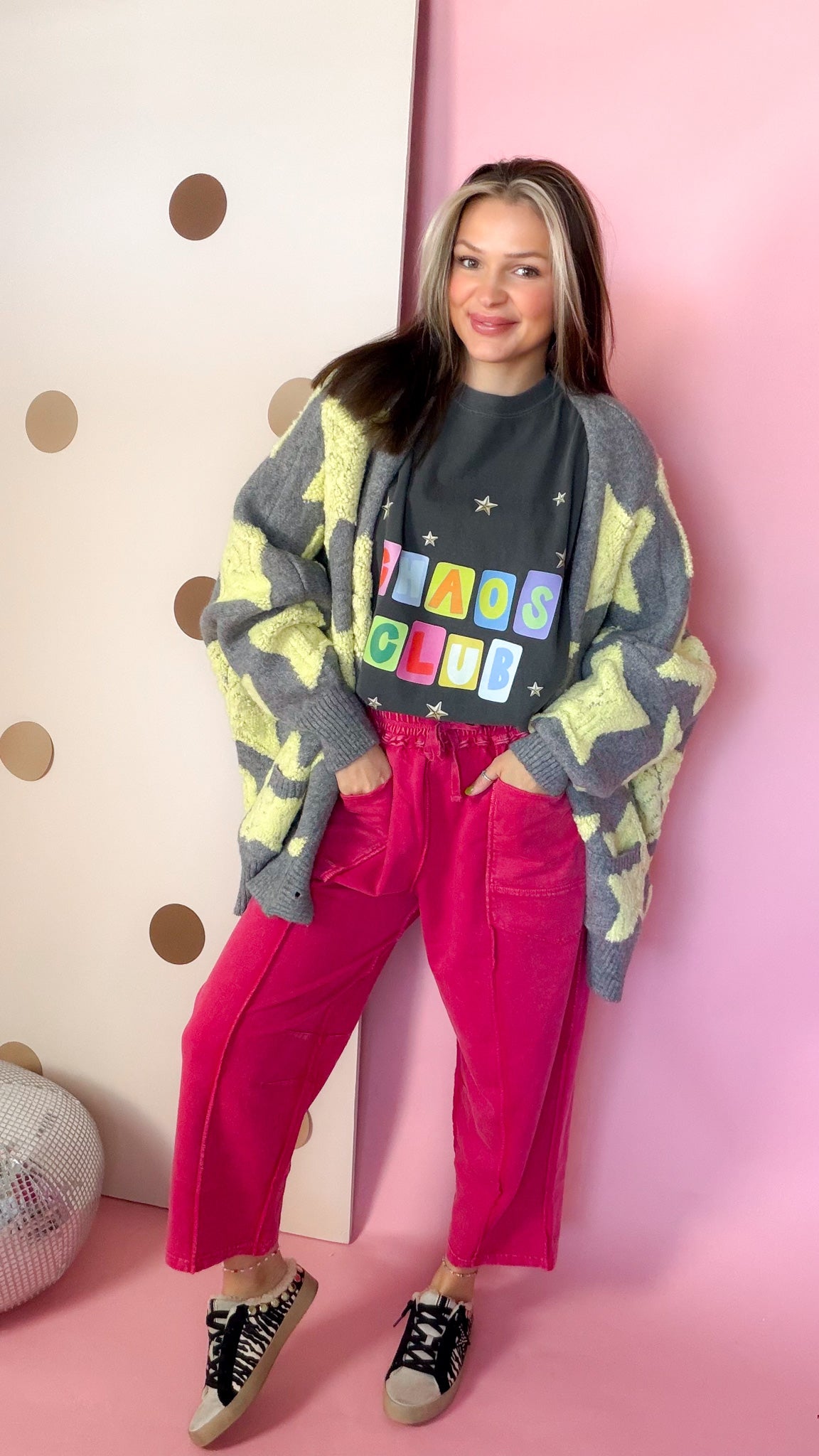 Model wearing Red terry knit barrel pants with a graphic tee and star cardigan, hands in front pockets.