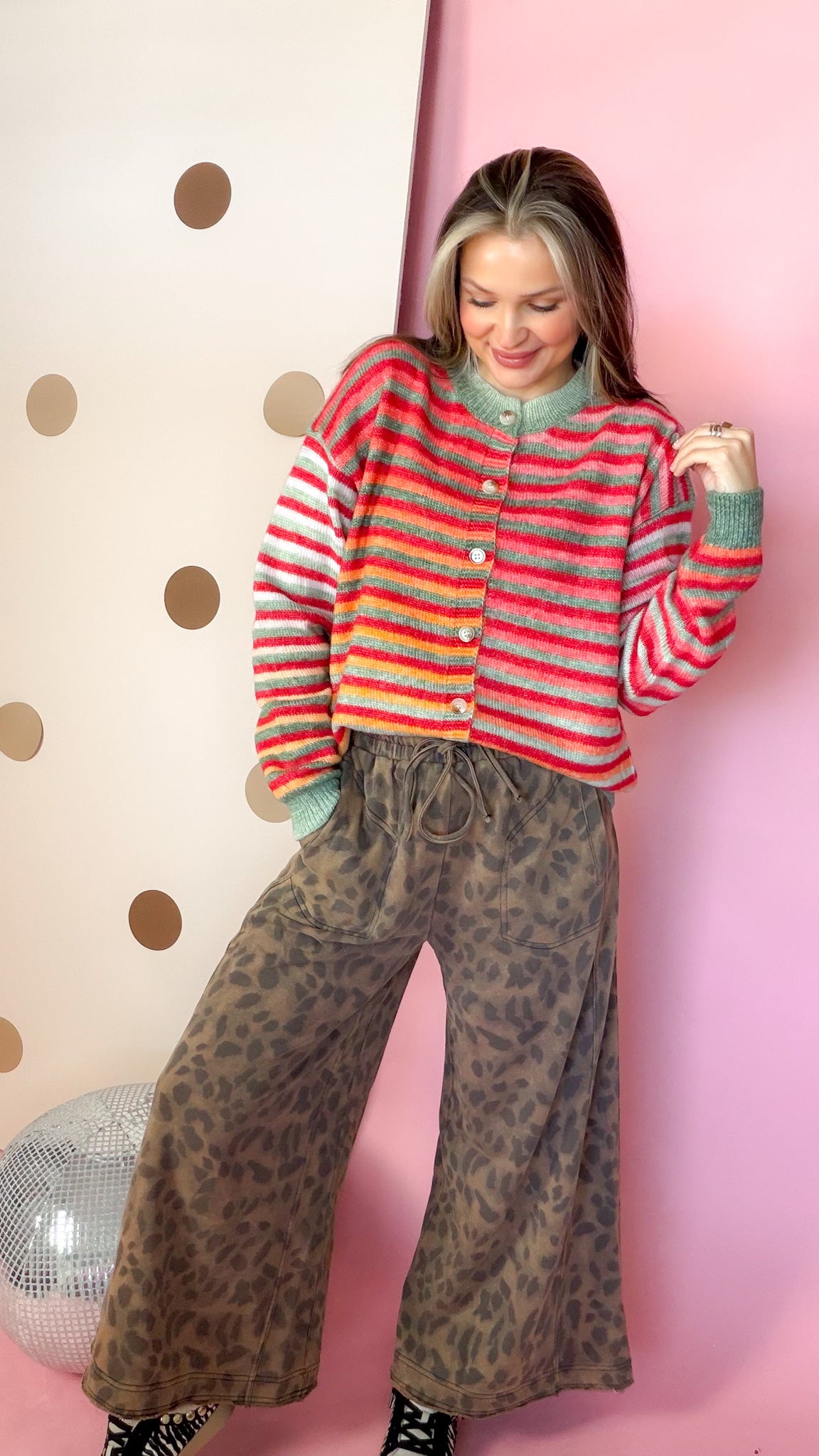 Mocha leopard wide leg pants paired with a colorful striped cardigan and black high-top sneakers.