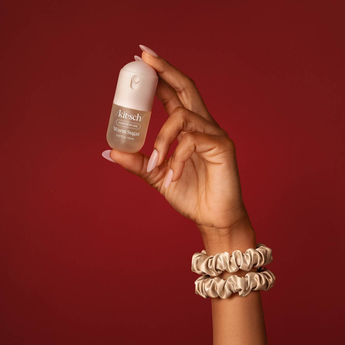 Kitsch Sweet and Silky Warm Sugar mini mist held up with satin scrunchies on the wrist