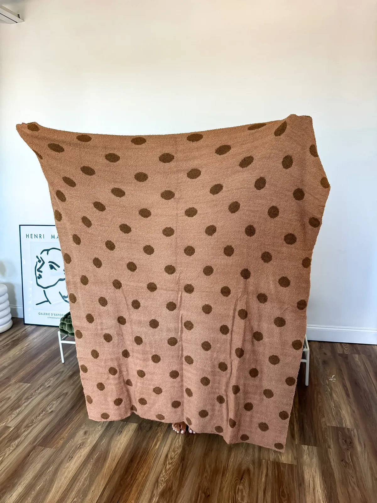 Reversible blanket with a light brown and dark brown polka dot pattern.