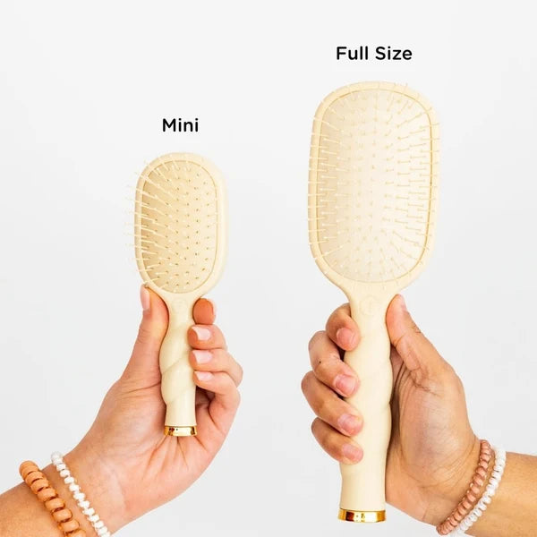 Model holding Teleties Mini and full size Detangler Brushes in tan to compare size