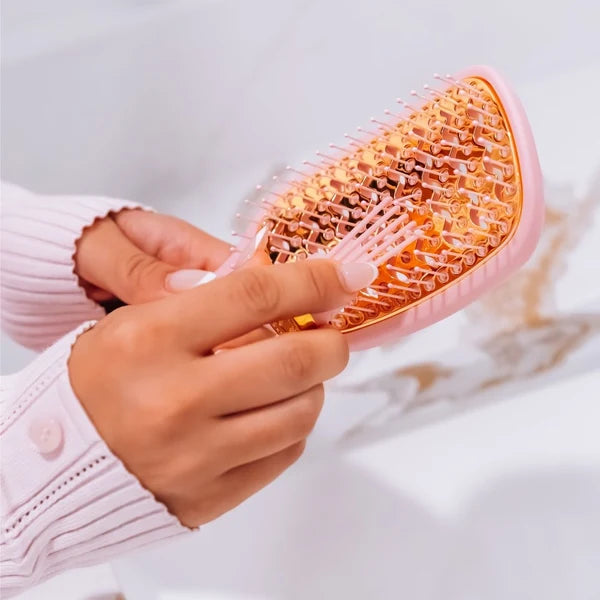 Hands holding the Teleties Vented Brush in Bubblegum Pink, close-up of bristles