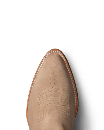 Tan cowboy boot with detailed stitching on a white background. Tecovas women’s cowboy boots