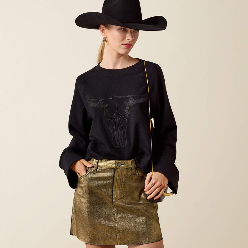 Women's Ariat Black Steer Statement Sweatshirt paired with cowgirl hat and metallic skirt
