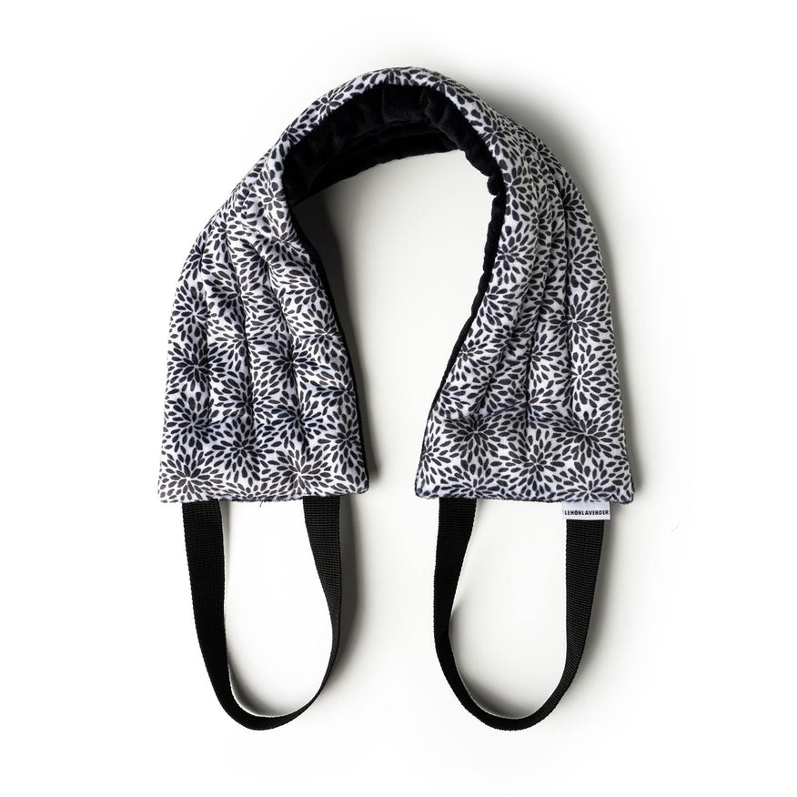 Hot Stuff Heated Neck Wrap in black and white leaf print, out of the box with black straps