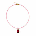 Quin Pendant Necklace in pink cord with red jewel pendant on a white background