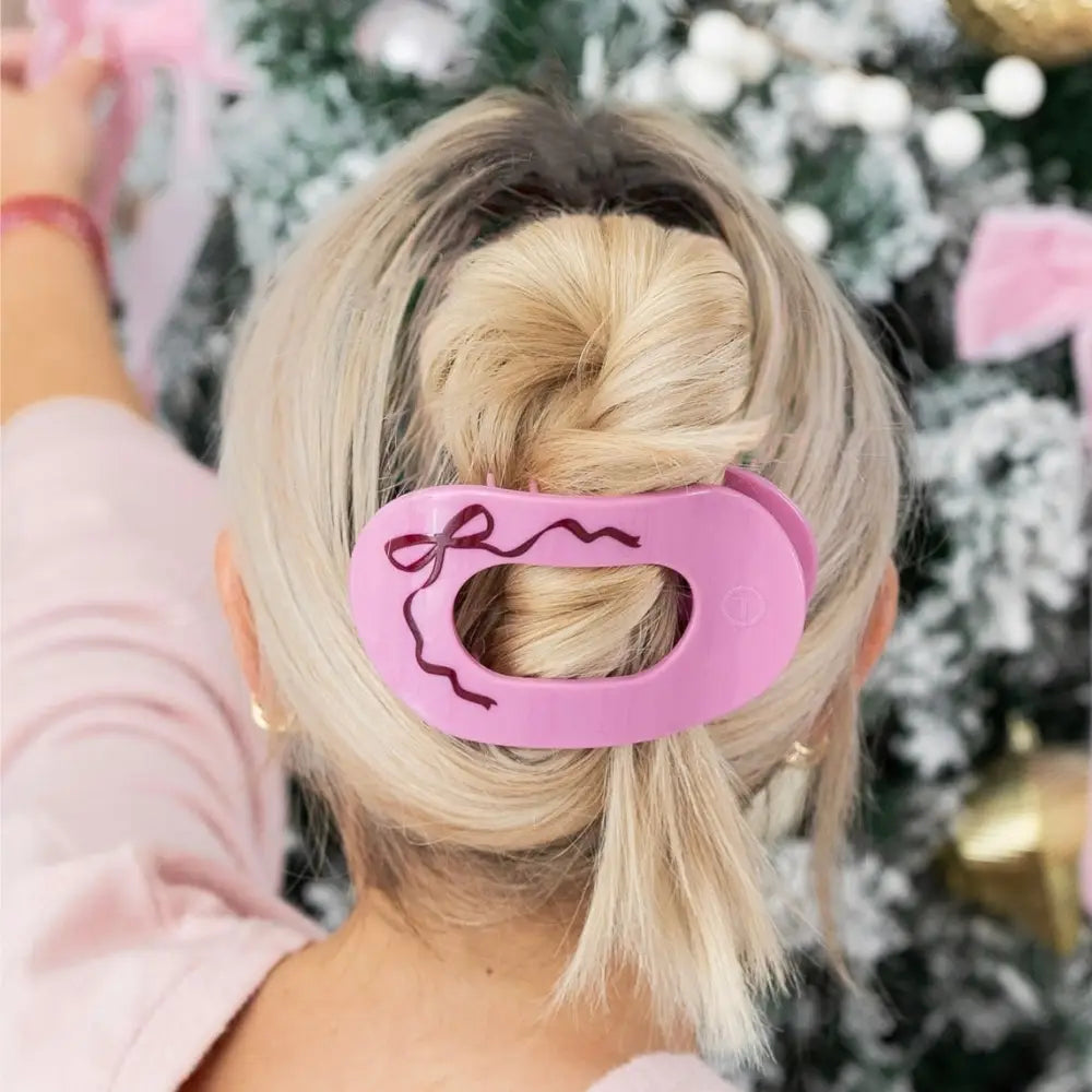 Teleties Just Add A Bow Large Flat Round Hair Clip in pink holding a blonde twisted updo