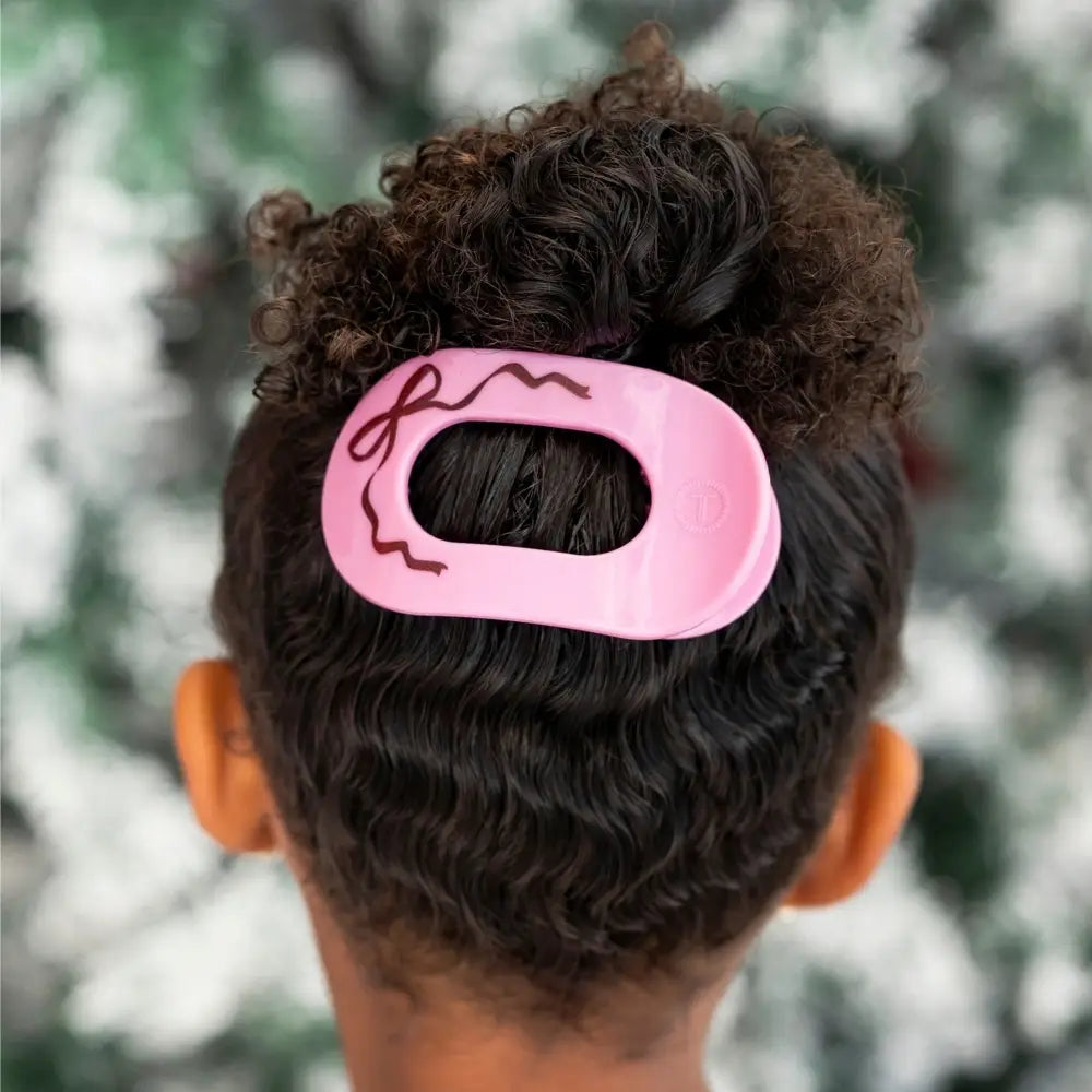 Teleties Just Add A Bow Small Flat Round Hair Clip in pink holding a curly bun