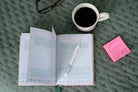 Praying Your Way to a Positive Mindset journal, open beside coffee and pen