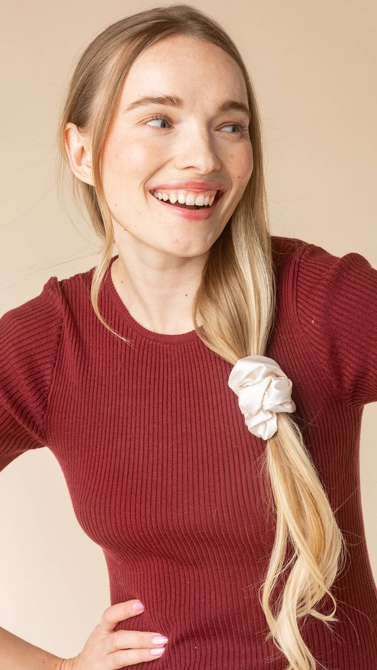 Kitsch cream satin scrunchie on the end of a side braid, smiling model