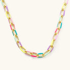 Pippa gold paperclip necklace with pink, lavender, yellow, mint and turquoise-blue accents on a light background.