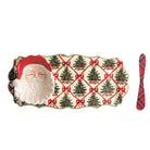 A Christmas-themed serving tray with a 3D Santa face on one end, a red Santa hat, and a pattern of green Christmas trees tied with red bows on a cream background. A red and black plaid napkin is placed to the right of the tray on a plain white background.