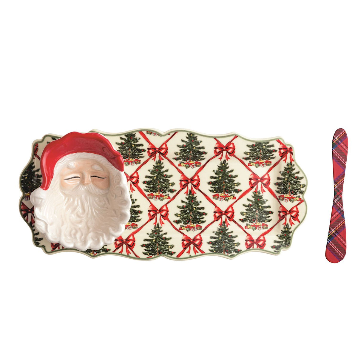 A Christmas-themed serving tray with a 3D Santa face on one end, a red Santa hat, and a pattern of green Christmas trees tied with red bows on a cream background. A red and black plaid napkin is placed to the right of the tray on a plain white background.