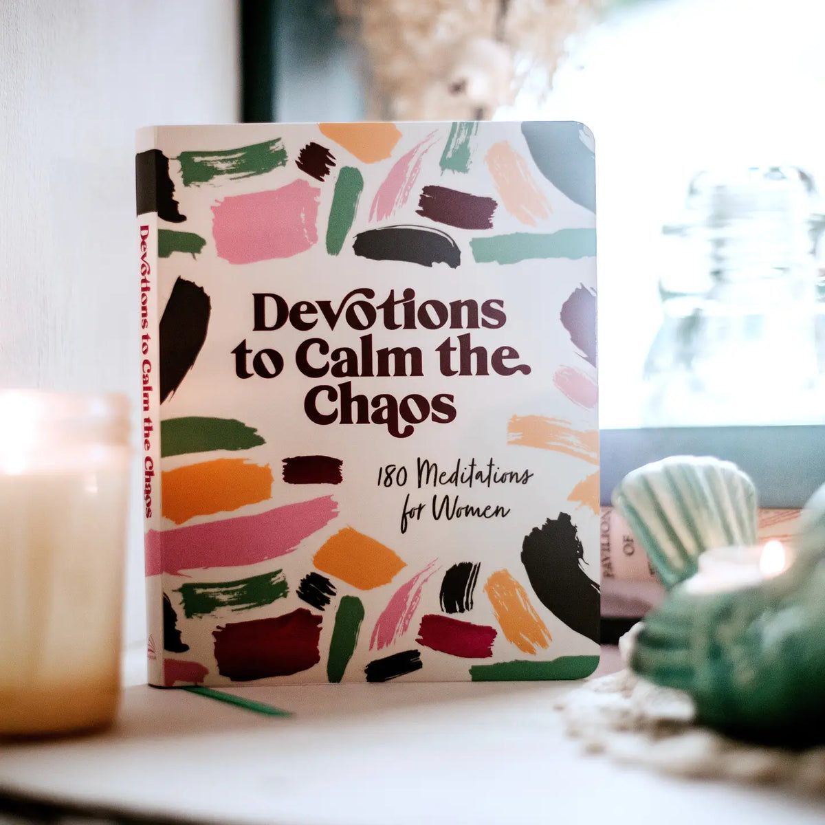 Devotions to Calm the Chaos, book standing beside a candle