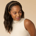 Woman wearing a beige headband against a beige background