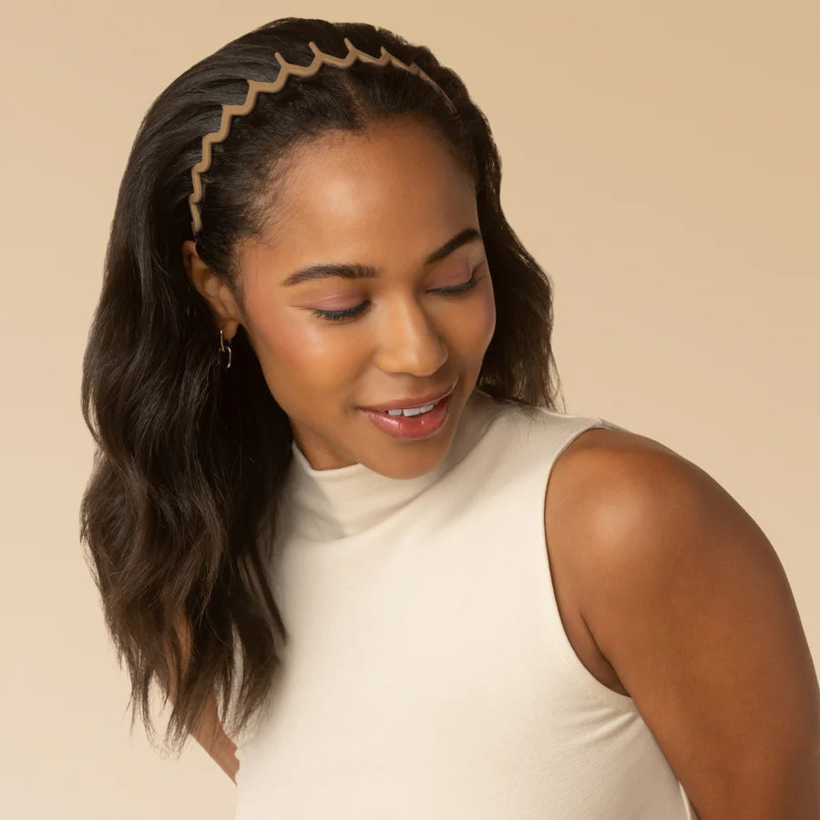 Woman wearing a beige headband against a beige background